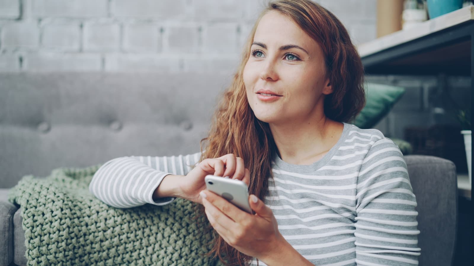 Woman reviewing her finances on a smartphone at home.